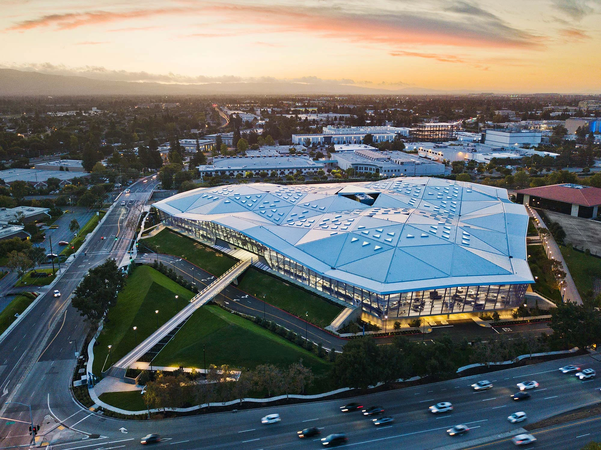 NVIDIA – Санта-Клара, КалифорнияТреугольная форма здания соответствует технологии компании.Сотрудники входят и уходят, проходя через зеленые насаждения.