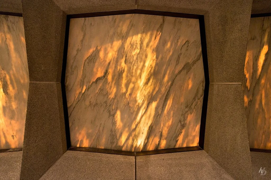 Снаружи белый мрамор с серыми прожилками кажется холодным и непроницаемым, но изнутри солнечный свет заставляет камень сиять с удивительной теплотой.