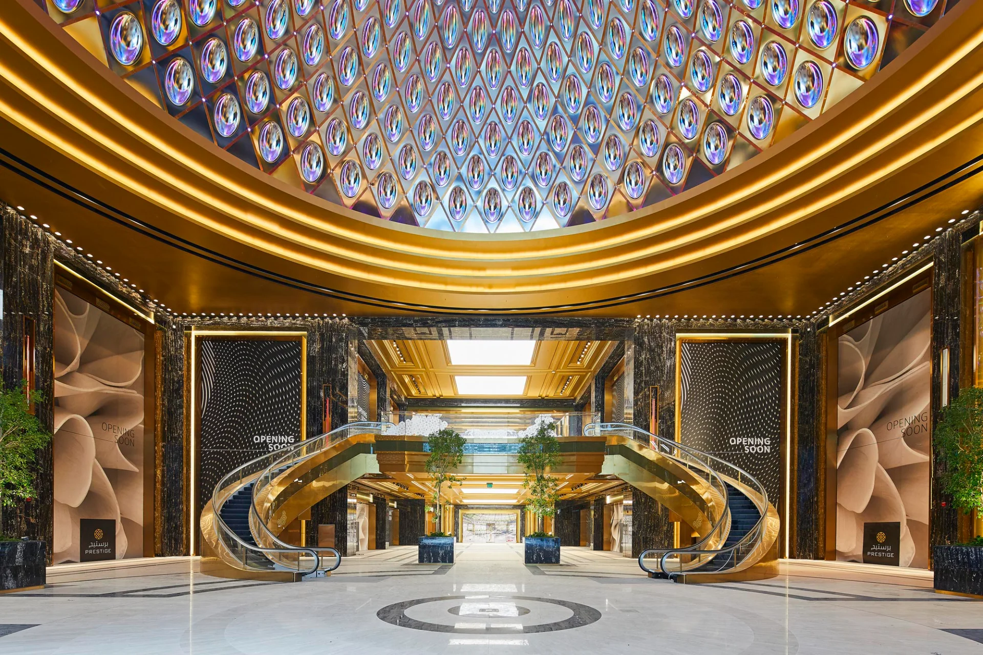 Вестибюль люксовой зоны Prestige в комплексе The Avenues. Композиция построена на строгой симметрии золотых эскалаторов, облицовке из темного мрамора и монументальном куполе с фацетированными зеркальными элементами. Вестибюль люксовой зоны Prestige в комплексе The Avenues. Композиция построена на строгой симметрии золотых эскалаторов, облицовке из темного мрамора и монументальном куполе с фацетированными зеркальными элементами.