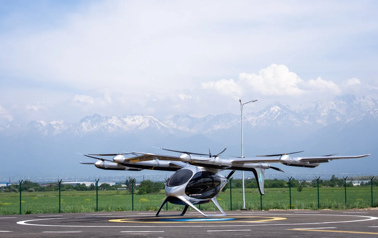 Электрический аппарат вертикального взлета и посадки (eVTOL) AutoFlight Prosperity на вертипорте в Alatau City на фоне гор. Этот вертипорт закладывает основу масштабного евразийского хаба UAM Center Eurasia. Источник: сайт https://alatau.city/ Электрический аппарат вертикального взлета и посадки (eVTOL) AutoFlight Prosperity на вертипорте в Alatau City на фоне гор. Этот вертипорт закладывает основу масштабного евразийского хаба UAM Center Eurasia. Источник: сайт https://alatau.city/
